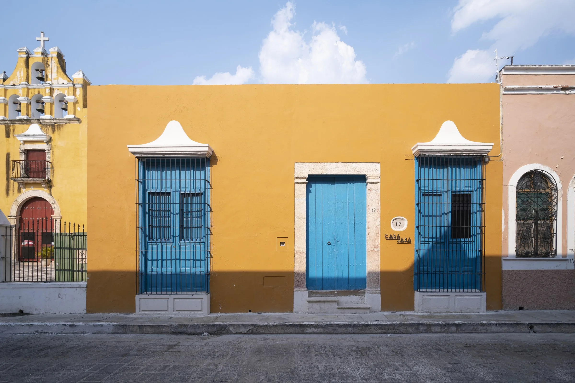 Fachada amarilla de Casa Japa con puerta y ventanas azules en la Calle 55 de Campeche